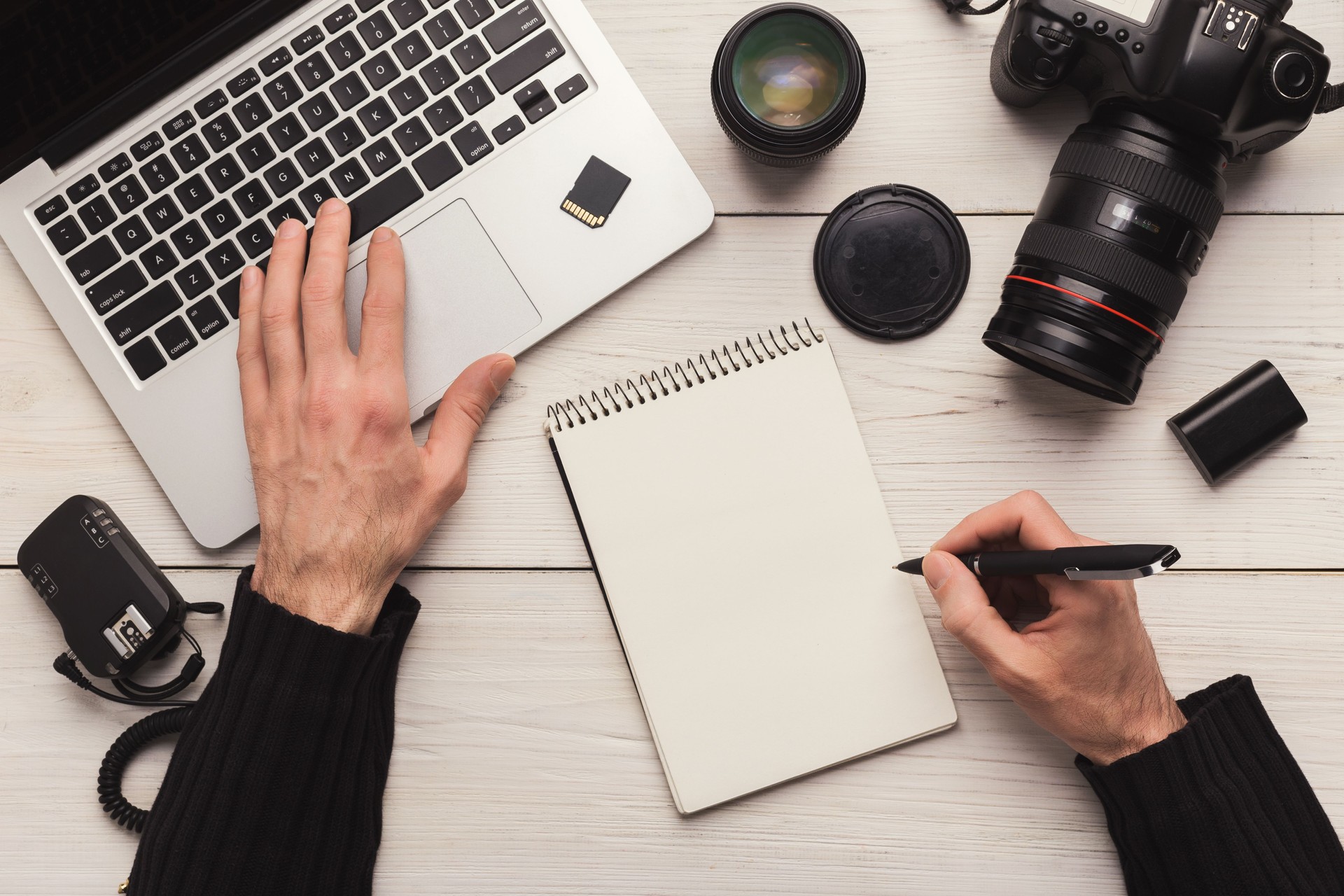 Photographer taking notes while using laptop